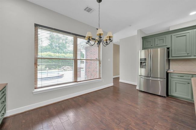 Breakfast area. Hallway ahead on the right is the Laundry Room and to the left is the back door. Between those is the 1/2 bath, near the back door. Pool can be seen through the window. | Image 17