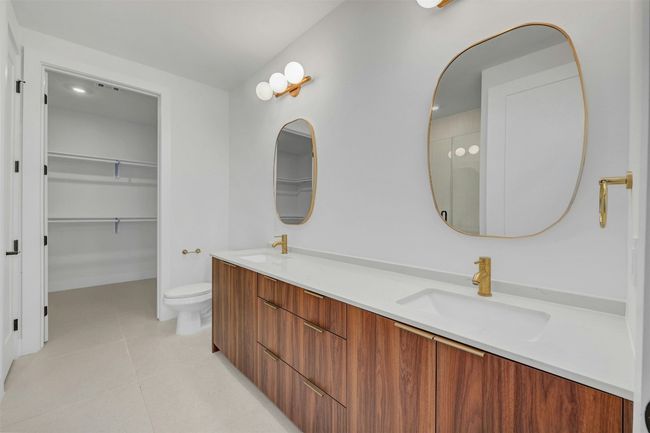 Full bath with double vanity, tile patterned floors, and a spacious closet | Image 13
