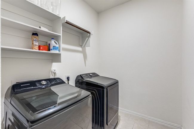 Laundry room with built in storage and light tile patterned floors | Image 11