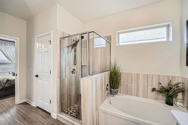 Bathroom with ensuite bath, a stall shower, wood finished floors, and a garden tub | Image 19