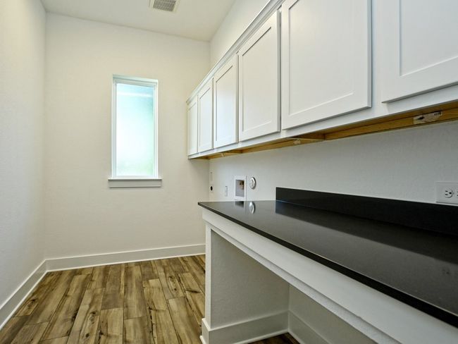 Washroom with cabinet space, dark wood-type flooring, electric dryer hookup, and washer hookup | Image 12