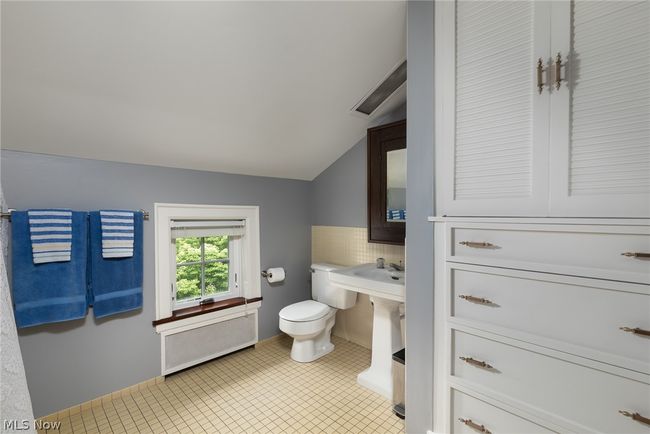 Bathroom with tile flooring, lofted ceiling, toilet, and backsplash | Image 36