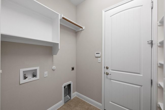 Laundry area with gas dryer hookup, hookup for a washing machine, electric dryer hookup, and tile patterned flooring | Image 27
