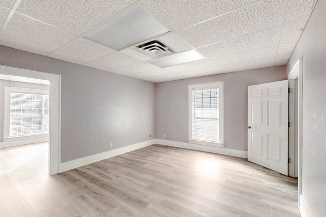 Empty room with a drop ceiling and light wood-type flooring | Image 17