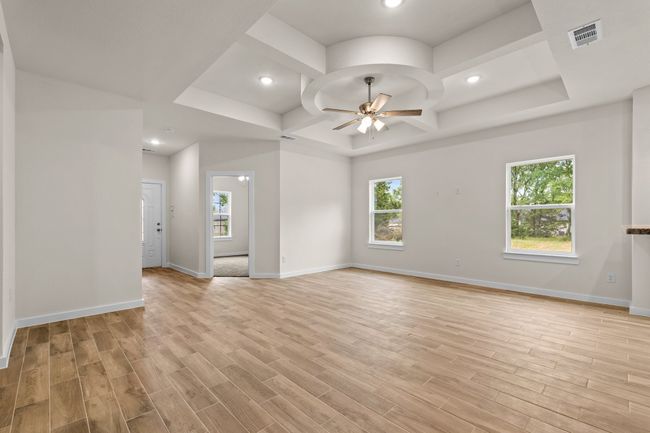 Living room featuring ceiling fan, healthy amount of natural light, coffered ceiling, light wood-type flooring, and recessed lighting | Image 5