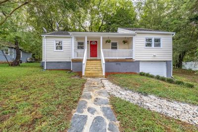 View of front facade with a front lawn, a garage, and covered porch | Image 1