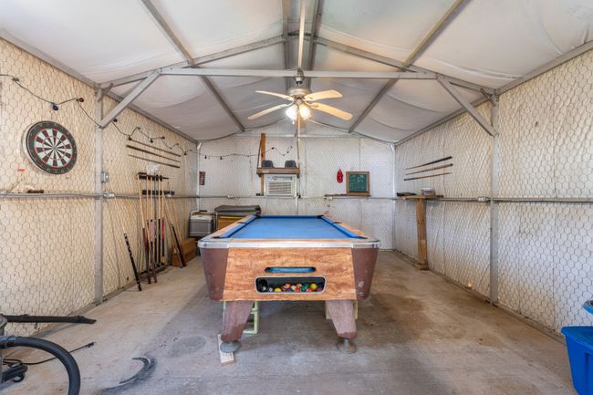 Game room with lofted ceiling, a ceiling fan, unfinished concrete flooring, and billiards | Image 23