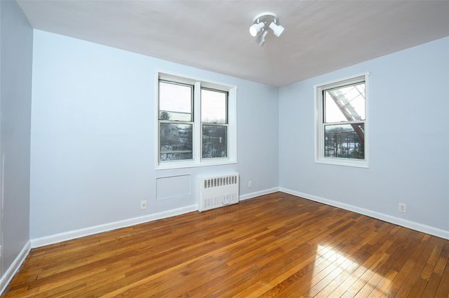 Empty room featuring wood-type flooring, radiator, and a healthy amount of sunlight | Image 15