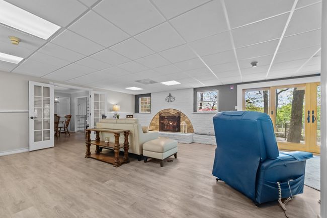 Living room with baseboards, wood finished floors, french doors, and a paneled ceiling | Image 6