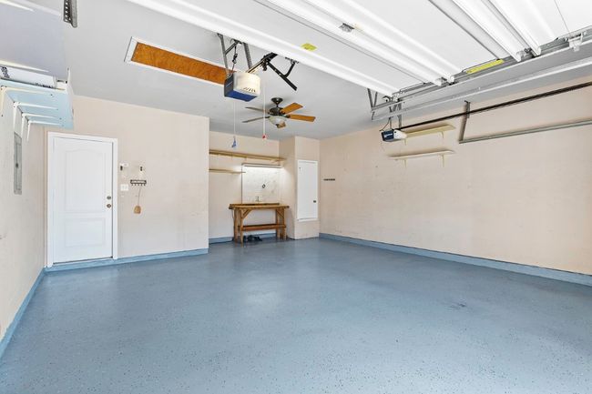 Garage with a garage door opener and ceiling fan | Image 28