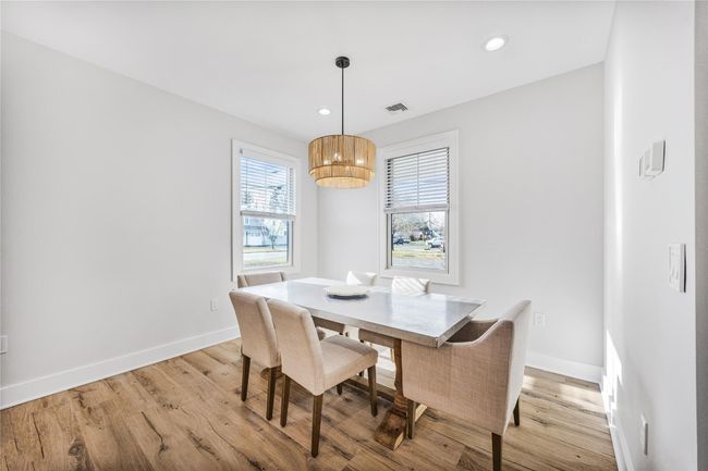 Dining space with baseboards, light wood-style flooring, visible vents, and a notable chandelier | Image 17