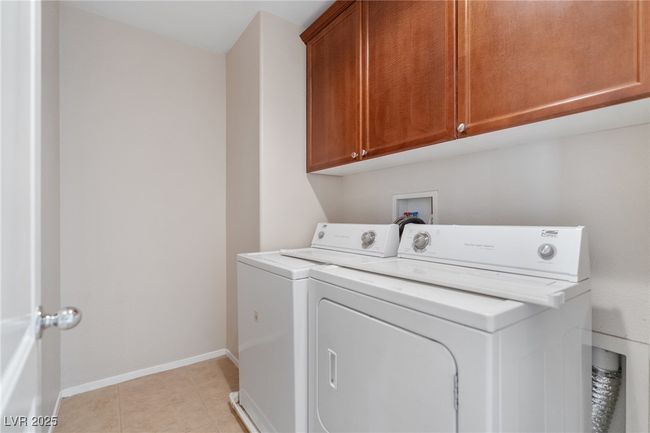 Laundry room with washer and dryer, cabinet space, and light tile patterned flooring | Image 7