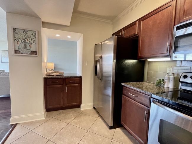Generous cabinetry throughout ensures ample storage for all your organizational needs. The contemporary touch of brushed nickel hardware beautifully adorns every cabinet door, adding a stylish and functional element to the kitchen. | Image 9