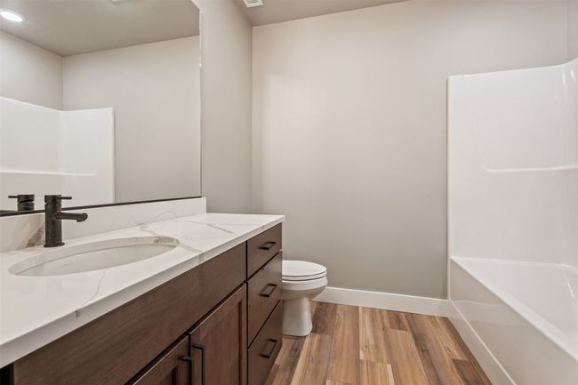 Full bathroom featuring wood finished floors, vanity, toilet, baseboards, and shower / bath combination | Image 34