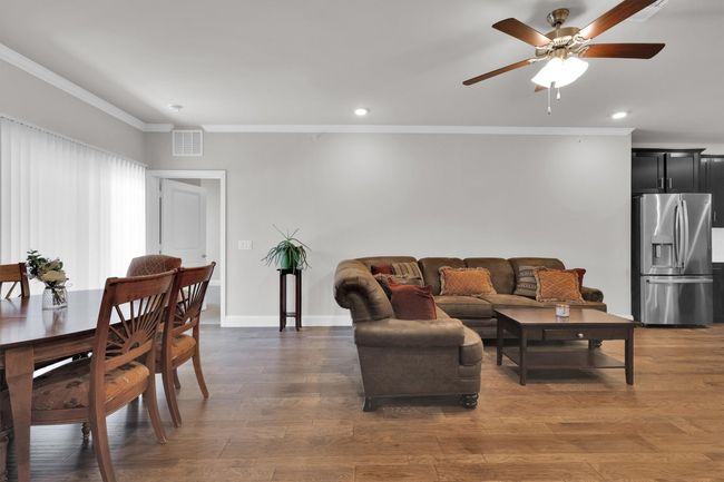 Living room with ornamental molding, ceiling fan, recessed lighting, baseboards, and wood finished floors | Image 9