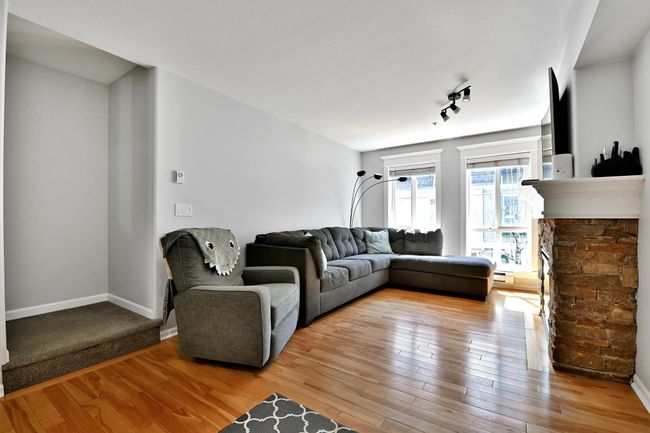 Living room with baseboard heating, light wood-type flooring, and baseboards | Image 7