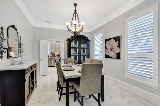 Dining space featuring light marble finish flooring, a chandelier, and ornamental molding | Image 5