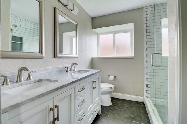 Bathroom with a shower stall, double vanity, and tile patterned flooring | Image 16