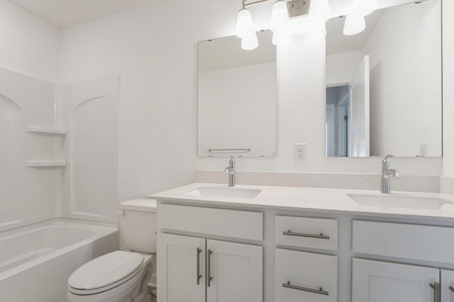 Photo is of the actual home. Featuring a double vanity, this secondary bath is sure to keep everyone moving during those busy mornings! | Image 14