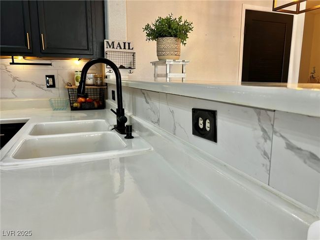 Room details with light countertops, a sink, and dark cabinetry | Image 9