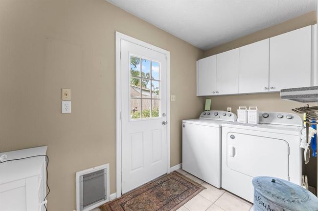 Laundry room with built-in cabinets and access to the large backyard. | Image 13