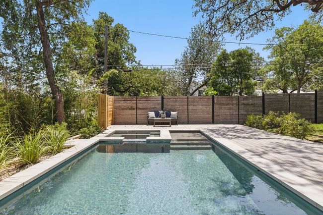 View of pool with a fenced backyard and a pool with connected hot tub | Image 34