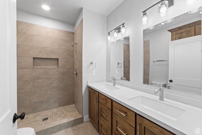 Full bath featuring a tile shower, a sink, toilet, and tile patterned floors | Image 31