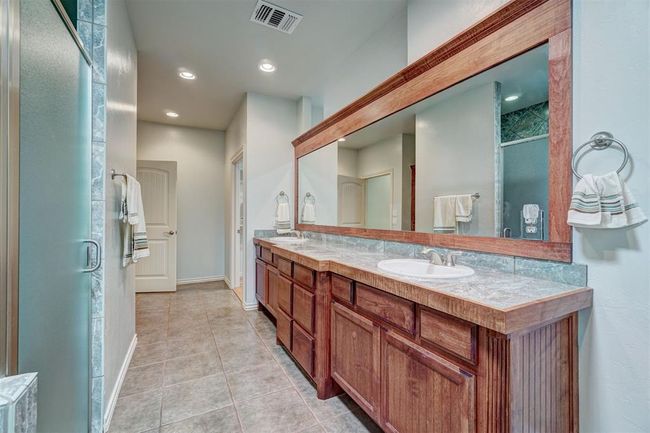 Full bath with tile patterned floors, double vanity, visible vents, a sink, and a stall shower | Image 27