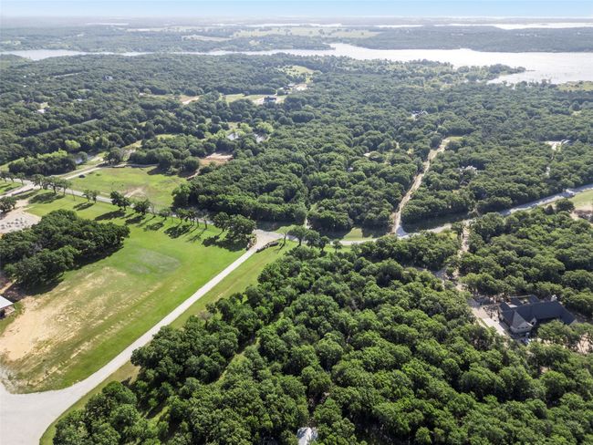 Aerial view of property and surrounding area featuring a large body of water and a heavily wooded area | Image 6