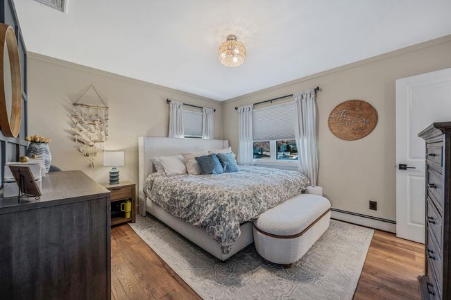 Bedroom with a baseboard heating unit and hardwood / wood-style flooring | Image 16