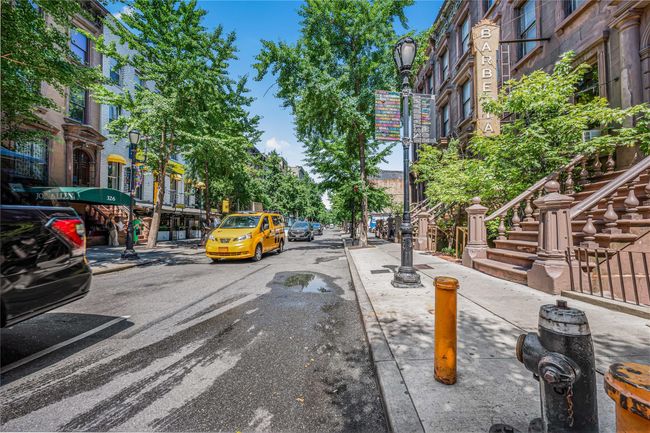 View of asphalt road featuring sidewalks, street lights, curbs, and stairs | Image 24