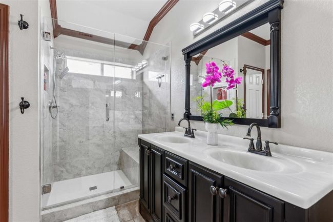 Full bath featuring a sink, a stall shower, and double vanity | Image 6