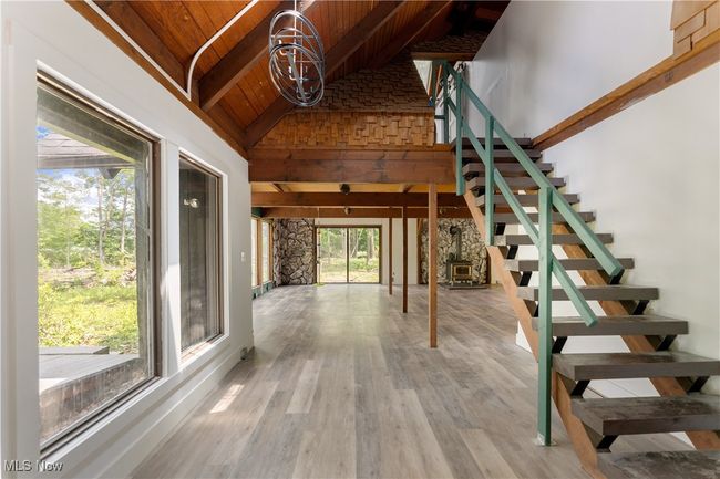 Stairs with wooden ceiling with exposed beams, healthy amount of natural light, wood finished floors, and high vaulted ceiling | Image 14