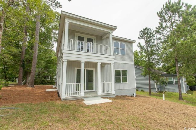 Back of property with a balcony, a yard, covered porch, and board and batten siding | Image 38