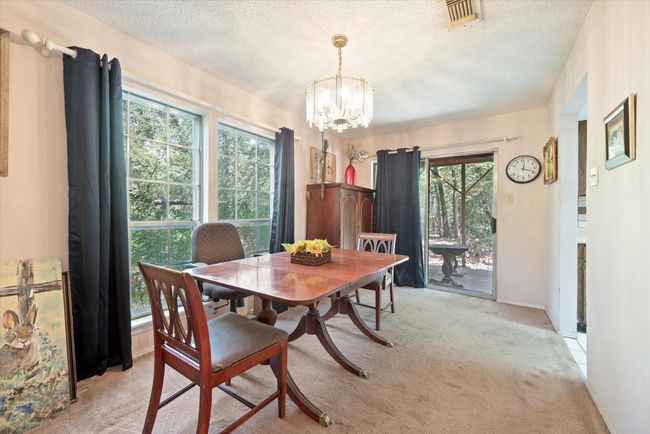 Carpeted dining space with plenty of natural light, a textured ceiling, and an inviting chandelier | Image 16