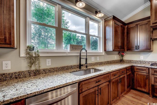Kitchen with dishwasher, ornamental molding, light stone counters, and light wood finished floors | Image 14