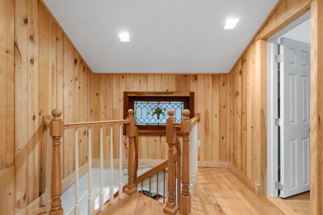 Spiral staircase landing with stained glass window. Note door leads to upper level bedroom. | Image 32
