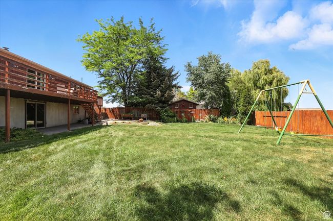 Fenced backyard with stairway, a wooden deck, and a playground | Image 31
