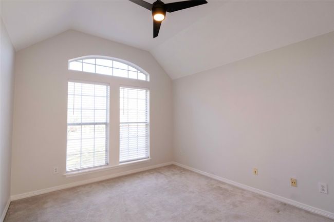 Empty room featuring lofted ceiling, light carpet, and a ceiling fan | Image 19