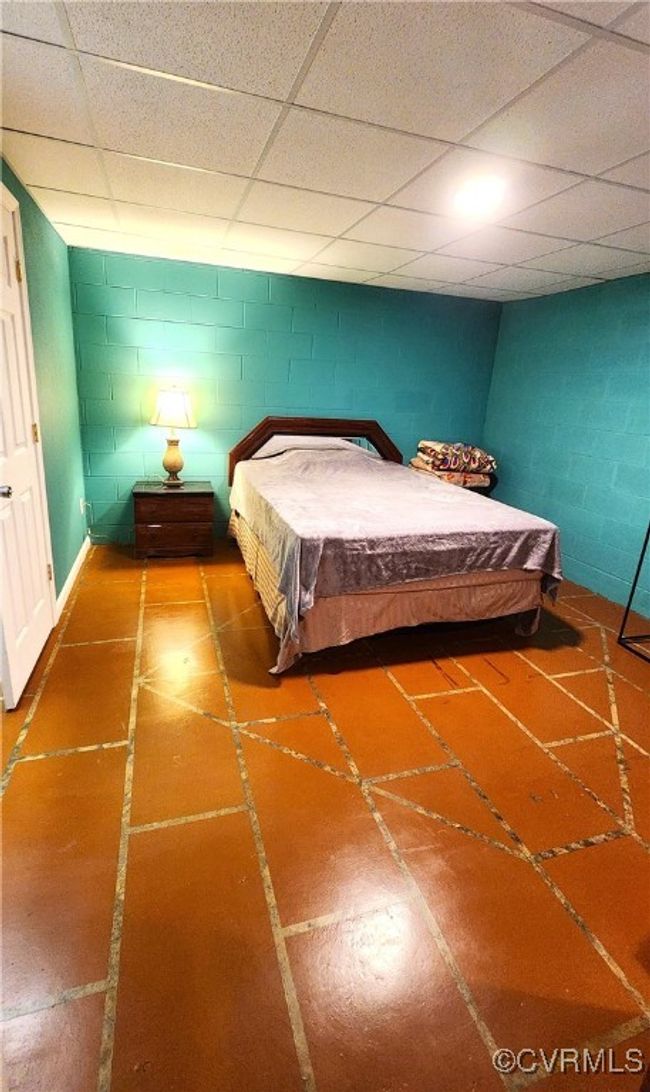 Bedroom featuring concrete block wall and a paneled ceiling | Image 29