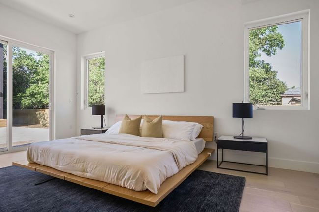 Bedroom featuring access to exterior, multiple windows, wood finished floors, and baseboards | Image 10