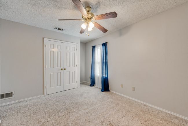 Unfurnished bedroom featuring a textured ceiling, carpet, a closet, and ceiling fan | Image 22