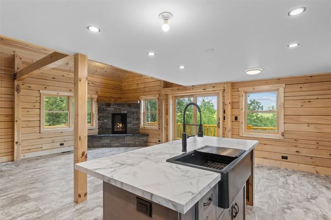Kitchen island looking towards stone fireplace in living area | Image 12
