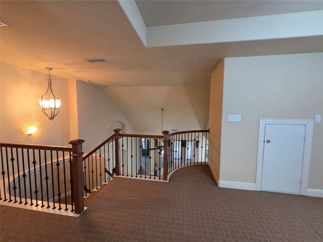 Hallway with an upstairs landing, carpet, and a chandelier | Image 33