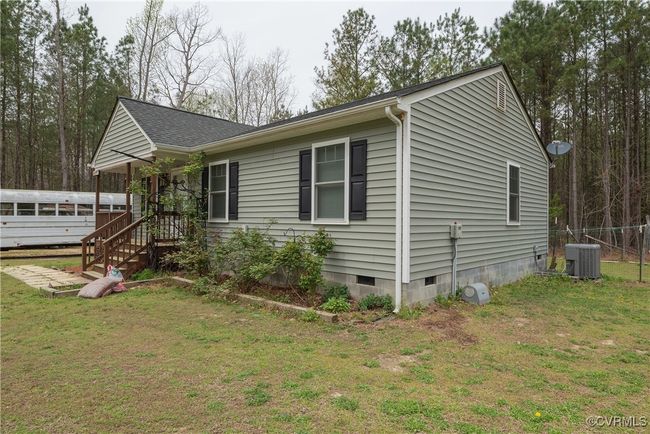 View of front facade with central air condition unit, crawl space, a front yard, and fence | Image 32