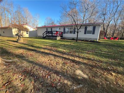 View of front of house with a front yard and a wooden deck | Image 1