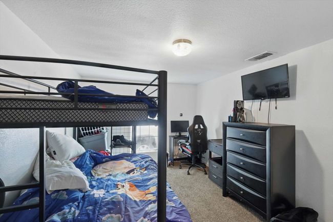 Carpeted bedroom with a textured ceiling and visible vents | Image 13