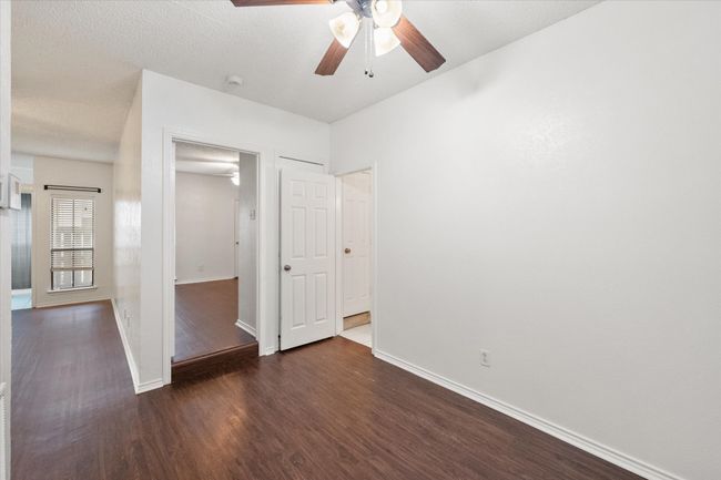Unfurnished bedroom featuring dark wood-style flooring and ceiling fan | Image 14