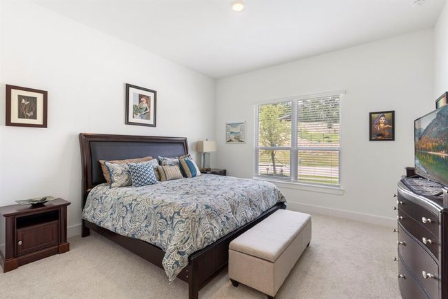 Cozy downstairs bedroom with natural light and serene views. | Image 31