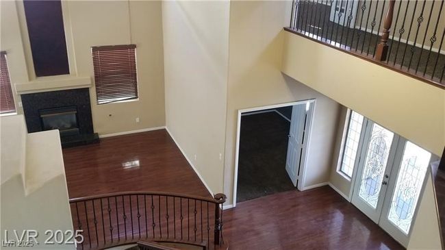 Foyer entrance featuring dark wood finished floors, a high ceiling, and a glass covered fireplace | Image 13